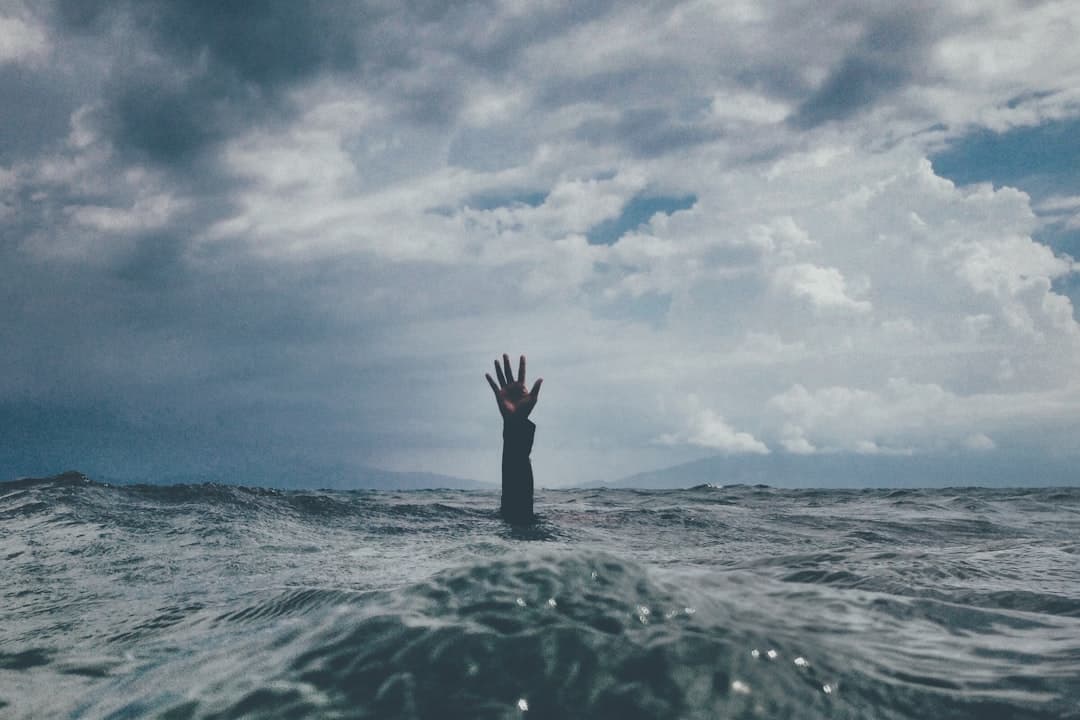 photo of person reach out above the water — Photo by nikko macaspac on Unsplash